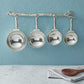 pewter twig measuring cups on wall strip