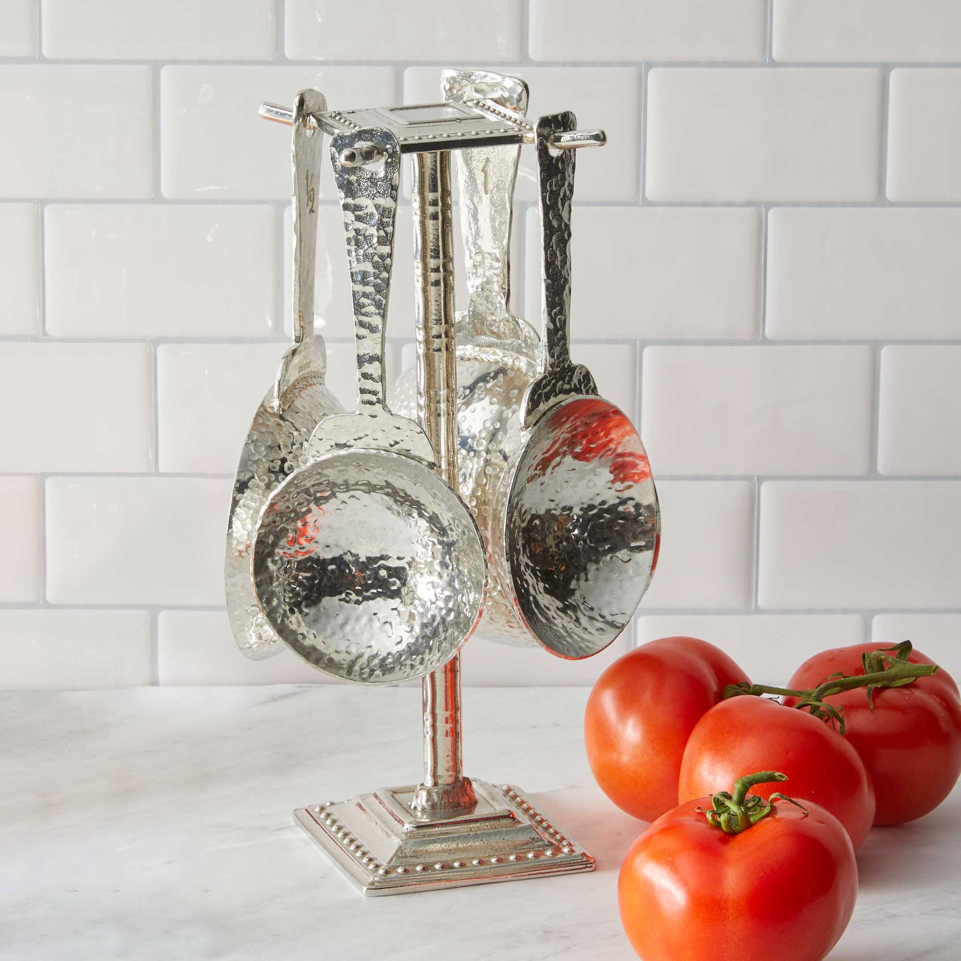 pewter roman measuring cups on counter post