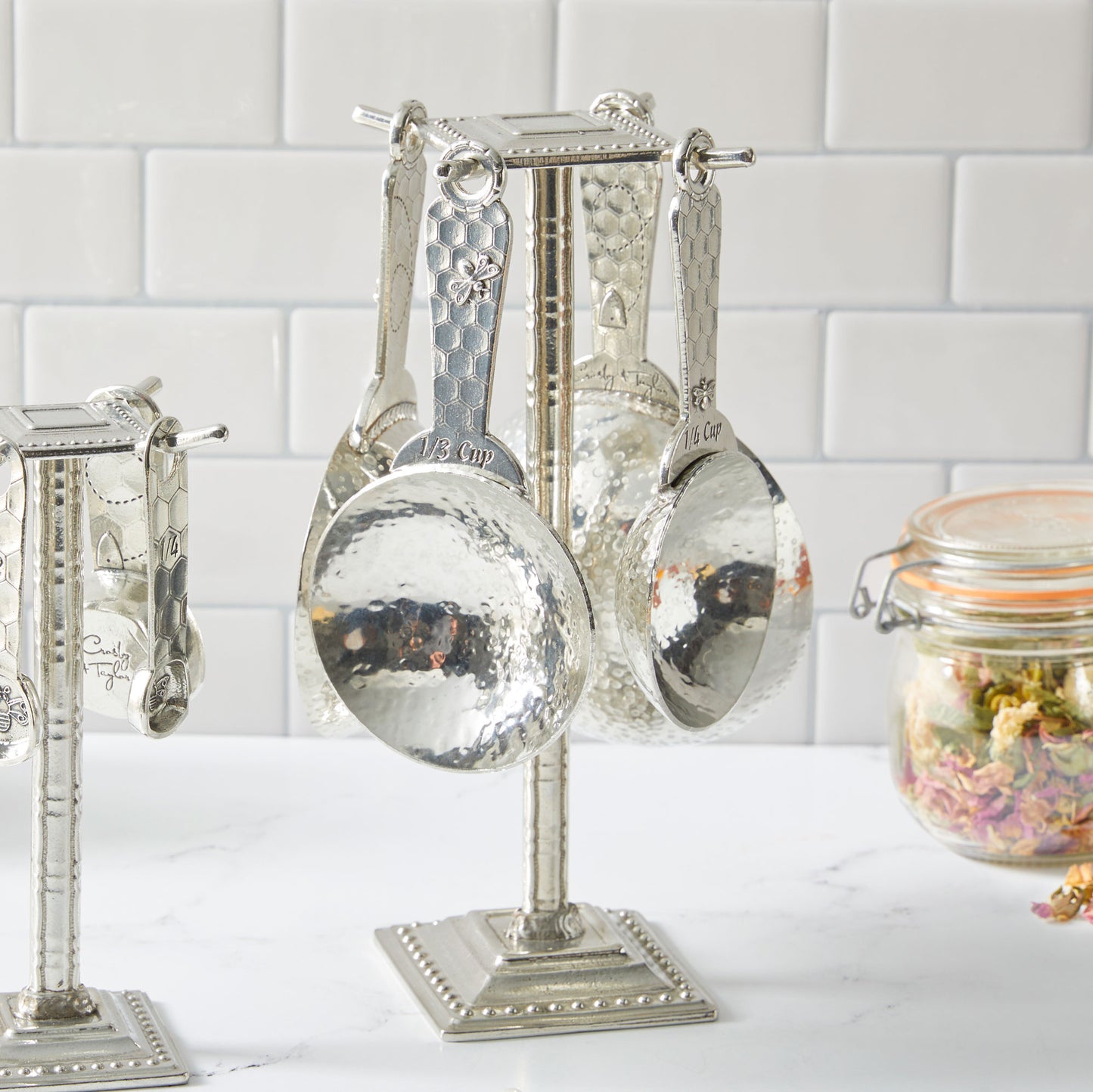 pewter honeybee measuring cups on counter post