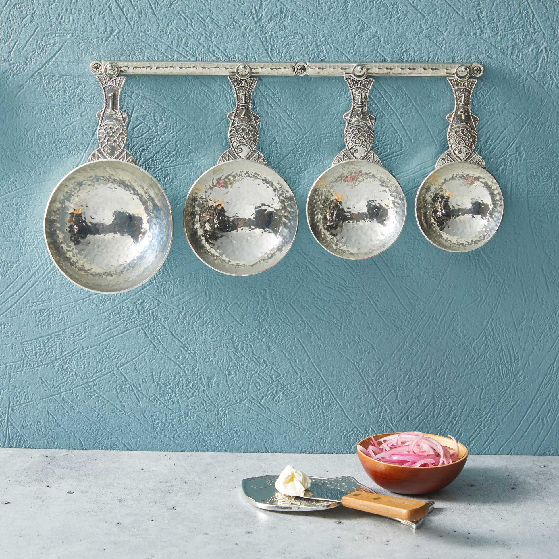 pewter fish measuring cups on wall strip