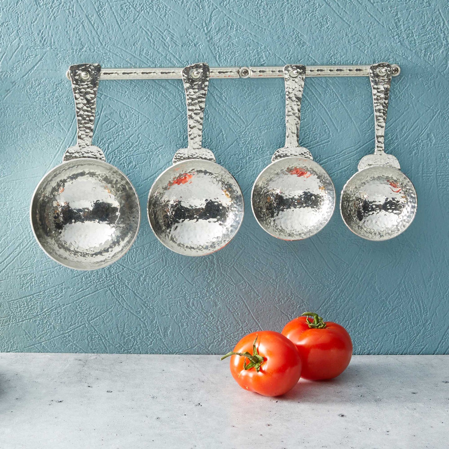 pewter roman measuring cups on wall strip
