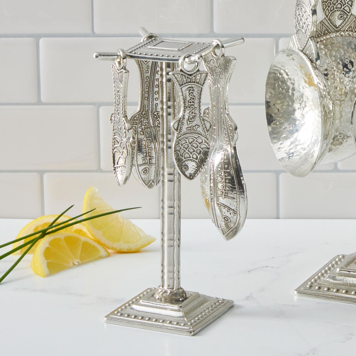pewter fish measuring spoons on counter post