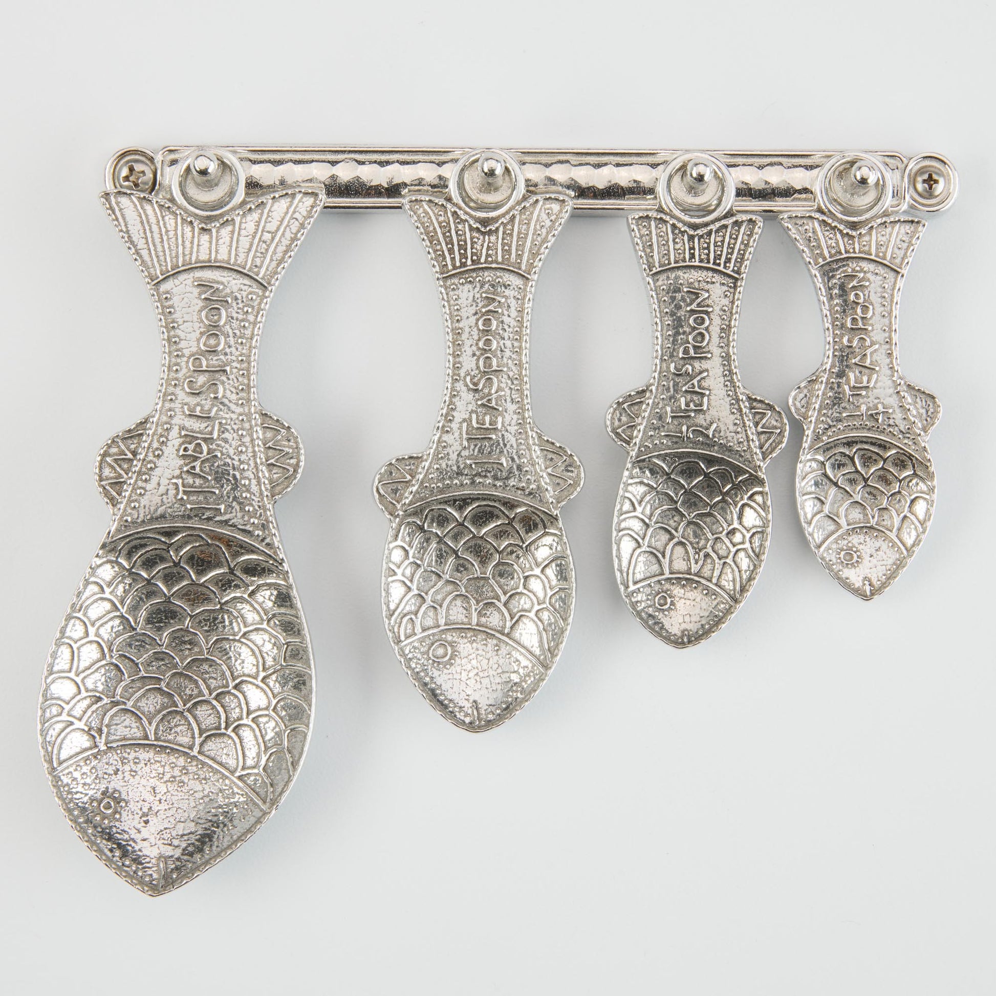 pewter fish measuring spoons on wall strip